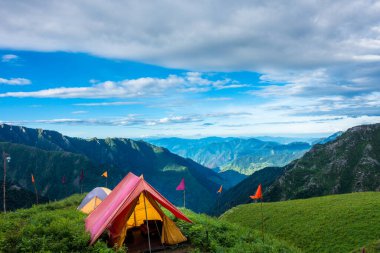 14 Temmuz 2022, Himachal Pradesh Hindistan. Güzel manzaralı çadır ve kamplar, arka planda vadi ve dağlar. Shrikhand Mahadev Kailash Yatra Himalayalarda.