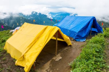 14 Temmuz 2022, Himachal Pradesh Hindistan. Güzel manzaralı çadır ve kamplar, arka planda vadi ve dağlar. Shrikhand Mahadev Kailash Yatra Himalayalarda.