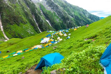 14 Temmuz 2022, Himachal Pradesh Hindistan. Bheem Dwari ana kampında çok renkli çadırlar var. Arka planda güzel dağlar ve şelaleler var. Shrikhand Mahadev Kailash Himalaya Yatra.