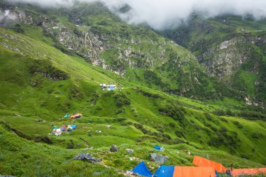 14 Temmuz 2022, Himachal Pradesh Hindistan. Bheem Dwari ana kampında çok renkli çadırlar var. Arka planda güzel dağlar ve şelaleler var. Shrikhand Mahadev Kailash Himalaya Yatra.