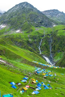 14 Temmuz 2022, Himachal Pradesh Hindistan. Bheem Dwari ana kampında çok renkli çadırlar var. Arka planda güzel dağlar ve şelaleler var. Shrikhand Mahadev Kailash Himalaya Yatra.