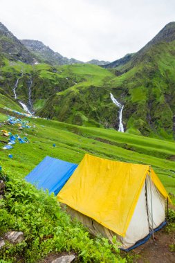 14 Temmuz 2022, Himachal Pradesh Hindistan. Bheem Dwari ana kampında çok renkli çadırlar var. Arka planda güzel dağlar ve şelaleler var. Shrikhand Mahadev Kailash Himalaya Yatra.