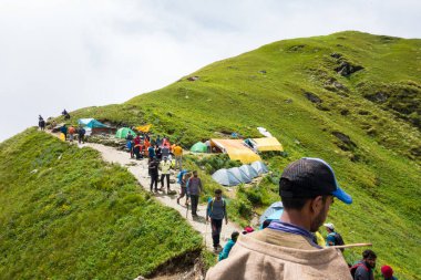 14 Temmuz 2022, Himachal Pradesh Hindistan. Sırt çantalı ve bastonlu insanlar, Himalayalar 'da Shrikhand Mahadev Kailash Yatra sırasında yürüyüş yapıyorlar..