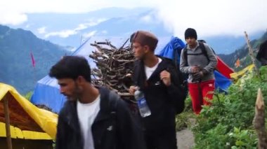 14 Temmuz 2022, Himachal Pradesh Hindistan. Sırt çantalı ve bastonlu insanlar, Himalayalar 'da Shrikhand Mahadev Kailash Yatra sırasında yürüyüş yapıyorlar..