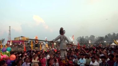 19 Ekim 2022, Dehradun, Uttarakhand, Hindistan. Vijayadashami Festival Fuarı (DUSSEHRA) sırasında denge çubuğuyla ip yürüyüşü yapan küçük bir kız kalabalığın önünde.