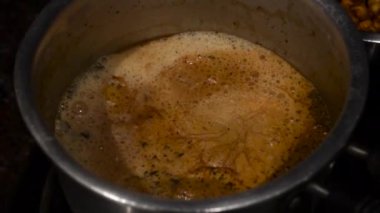 Hint Mutfağı 'ndaki bir gaz ocağında hazırlanırken sütlü çay kaynıyor. Masa üstü görünümü. Uttarakhand Hindistan.