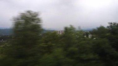 Mata Vaishno Devi Tapınağı 'na seyahat ederken hareket halindeki bir trenin penceresinden şehir manzarası ve vadisinin dışı. Katra Express Jammu ve Kaşmir.