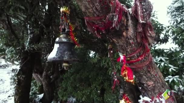 背景に雪に覆われた山々 Kartik Swami寺 Rudrapraag Uttarakhand インドで聖なる赤い布で鐘をぶら下げるの映画的なスローモーションショット — ストック動画