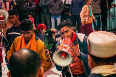 31 Ocak 2023, Tehri Garhwal, Uttarakhand, India.Adam hoparlörden yerel bir halk şarkısı söylüyor. Geleneksel Dans ve Müzik Festivali Uttarakhand tepelerinde düzenlenen düğün töreninde.