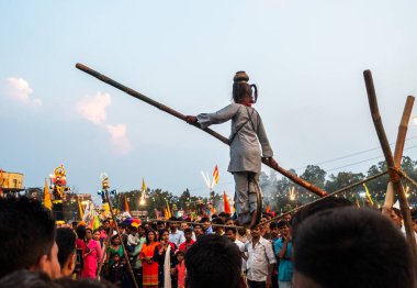 19 Ekim 2022, Dehradun, Uttarakhand, Hindistan. Vijayadashami Festival Fuarı (DUSSEHRA) sırasında denge çubuğuyla ip yürüyüşü yapan küçük bir kız kalabalığın önünde.