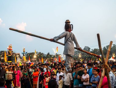 19 Ekim 2022, Dehradun, Uttarakhand, Hindistan. Vijayadashami Festival Fuarı (DUSSEHRA) sırasında denge çubuğuyla ip yürüyüşü yapan küçük bir kız kalabalığın önünde.