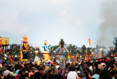 19 Ekim 2022, Dehradun, Uttarakhand, Hindistan. Vijayadashami Festival Fuarı (DUSSEHRA) sırasında denge çubuğuyla ip yürüyüşü yapan küçük bir kız kalabalığın önünde.