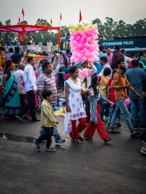 19 Ekim 2022, Dehradun, Uttarakhand, Hindistan. Hintli bir anne çocuklarını festivale götürüyor..