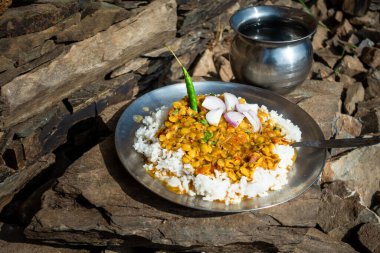 Hint yemeği tabağı, sarı mercimek ya da dal pirinçle birlikte taş bir tepside salatalar, kamp sırasında açık hava yemekleri. Uttarakhand Hindistan.
