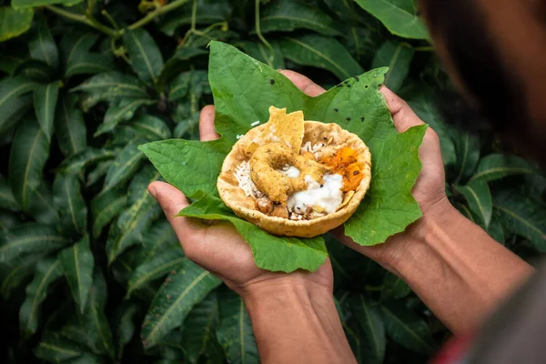 Hands offering food placed on a green leaf during a Hindu Ritual in the month of Sharada. Indian Customs and Traditional.