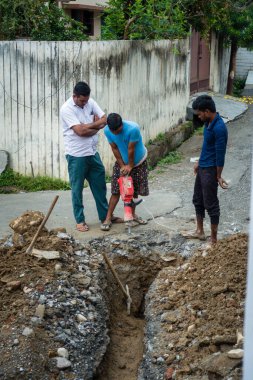 14 Ekim 2022 Uttarakhand, Hindistan. Uttarakhand, Hindistan 'da boru hattını kazmak için matkap kullanan bir işçi. İlerleme ve gelişim eylemde gösteriliyor.