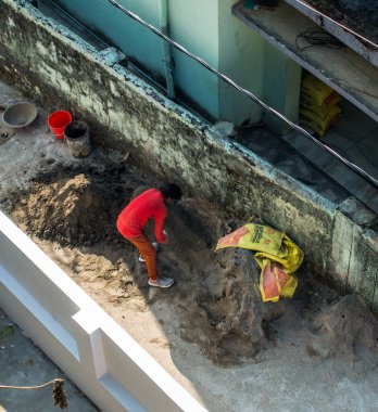 14 Ekim 2022 Uttarakhand, Hindistan. Şantiyede çalışan bir adamın kuş bakışı görüntüsü, Dehradun şehrinde elle kum dolduran bir adam. Sıkı çalışma devam ediyor.
