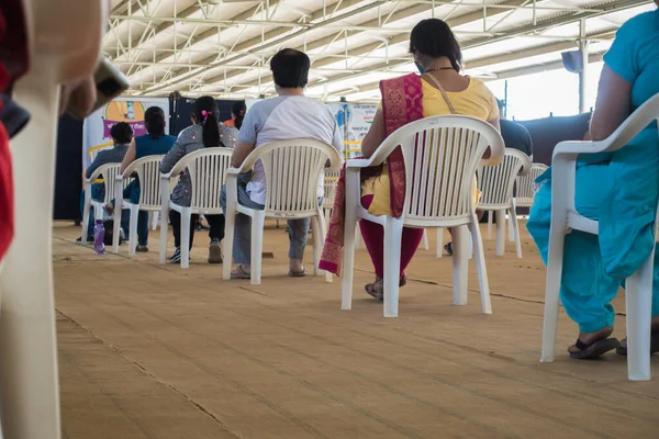 stock image Oct.14th 2022 Uttarakhand, India. Individuals seated in chairs with face masks, practicing social distancing at a COVID vaccination camp in Dehradun City. Safety-first approach.