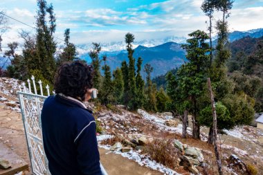 14 Ekim 2022, Uttarakhand Hindistan. Çay yudumlayan turistler, Garhwal, Uttarakhand, Hindistan 'da kar kaplı Himalayalar' a hayranlık duyuyorlar. Sakin dağ manzarası