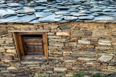 Ayrıntılı görüş: Hindistan 'ın Uttarakhand şehrinde kayalar ve çamurdan yapılmış geleneksel taş kulübe. Taşra işçiliği.