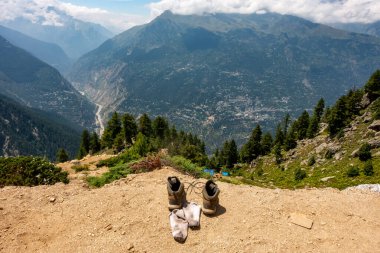 Hindistan 'daki Himachal Pradesh' te uzun bir günün ardından vadilere ve dağlara bakan yürüyüş ayakkabılarının yaratıcı bir çekimi..