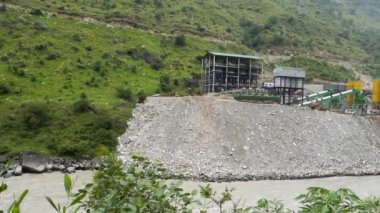 30 Ağustos 2023, Himachal Pradesh, Hindistan. Satluj Nehri 'ndeki bir hidroelektrik santralindeki ağır makineler nehir kıyısında aşınmaya neden oluyor. Nehir yıkım sahnesi.
