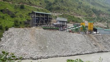 30 Ağustos 2023, Himachal Pradesh, Hindistan. Satluj Nehri 'ndeki bir hidroelektrik santralindeki ağır makineler nehir kıyısında aşınmaya neden oluyor. Nehir yıkım sahnesi.