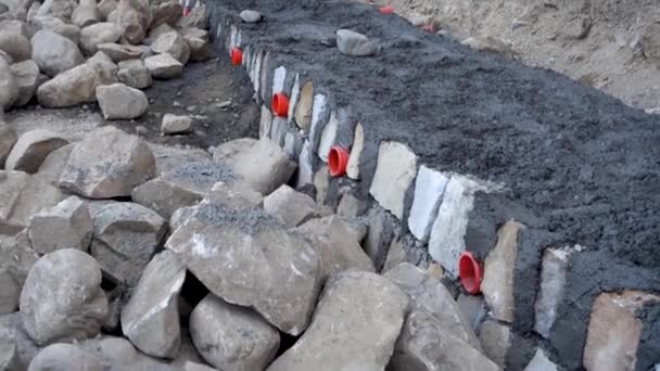 Uma Parede Retenção Pedra Sob Construção Com Bueiros Laranja Tubos — Vídeo de Stock