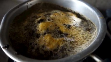 Hint Evi 'nin mutfağındaki bir gaz ocağında sütlü çay hazırlığı. Masa üstü görünümü. Uttarakhand Hindistan.