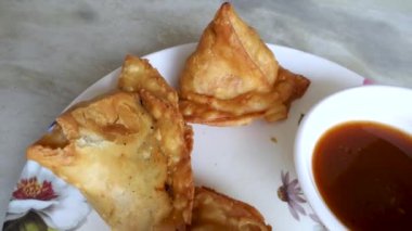 Demirhindi soslu ya da baharatlı Samosa. Samosa ya da singara, baharatlı patates, soğan ve bezelye gibi içerikleri içeren lezzetli bir dolgusu olan kızarmış ya da fırında pişirilmiş bir hamur işidir. Uttarakhand Hindistan.