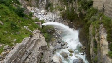 Hindistan 'daki Himachal Pradesh musonu sırasında acil su çıkışı zorla nehre dökülüyor.