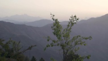 Sabah güneşi Uttarakhand, Hindistan 'daki Naag Tibba Dağı' nda parlayarak sisli bir atmosfer yaratıyor..