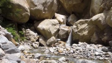 Manzaralı Himalaya şelalesi Himachal Pradesh, Hindistan 'daki devasa kayaların arasında. Kinner Kailash Yatra 'nın bir parçası, bir Hindu haccı..