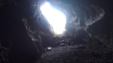 Derin bir mağaradan dışarı bakıyor, güneş ışığı Himalayalar 'ın Uttarakhand, Hindistan' daki bir mağarasının içinden geçiyor..