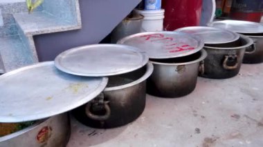 13 Nisan 2022, Dehradun Şehri Uttarakhand Hindistan. Büyük güveç tencereleri ya da kazanlar halka açık bir ziyafet sırasında yemekle birlikte sıraya dizilmişti. Hindistan 'da Pateela olarak bilinir..