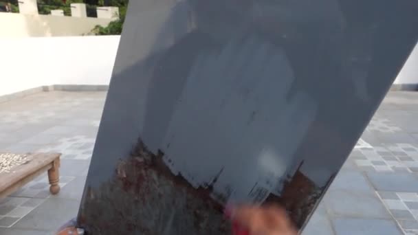 グレーペイントの表面にレッドペイントブラシを保持する手のクローズアップショット インド — ストック動画