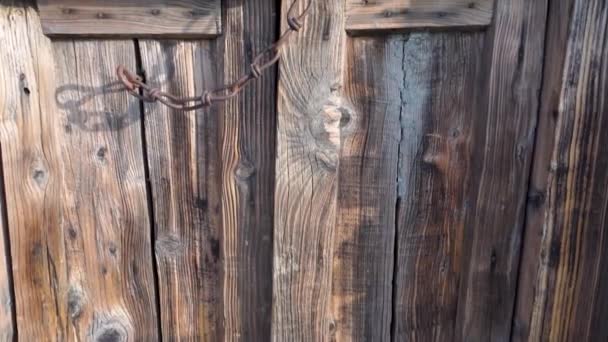 Eine Alte Strukturierte Holztür Mit Einer Kette Aus Gusseisen Die — Stockvideo