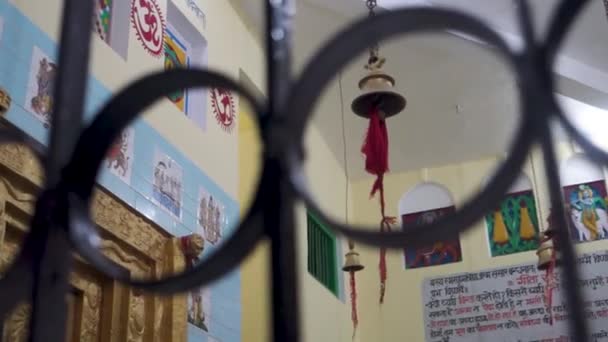 2022年11月30日 テヘリ ガーウォル ウッタルカンド インディア 壁に掛かる鐘 赤い神聖な布 ヒンディー語の聖典で飾られたヒンドゥー寺院の内部は インドの文化を展示しています — ストック動画