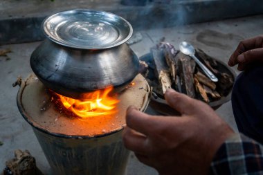 3 Mart 2024, Uttarakhand Hindistan. Angeethi Aşçılık: Hindistan 'ın Uttarakhand köyünde yakacak odunlu açık hava kil ocağı.