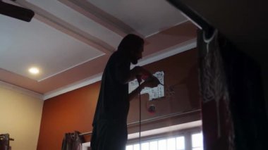 10 Haziran 2024, Dehradun Şehri, Hindistan. Ev tadilatı sırasında duvarları delen adamın görüntüsü. Şehir inşaat konsepti. DIY projesi. Ev tadilatı. Elektrikli aletler. İşçi işte..