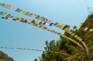 Uttarakhand dağlarında dalgalanan renkli dua bayraklarının görüntüleri. Rüzgarlı bir öğleden sonra. Mavi gökyüzü. Himalaya manzarası. Ruhani gelenek. Dağ manzarası. Kültürel semboller. Sakin doğa..