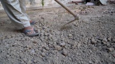 Yerli bir adam tarlasına bakıyor, Dehradun, Uttarakhand, Hindistan 'daki bahçe aletleriyle toprağı eğip kazıyor, hasat öncesi mevsimde.