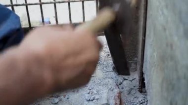 Hindistan 'daki bir inşaat sahnesinde beton kesme eylemindeki el kesimi, el aletleri ve el işçiliği sergileniyor