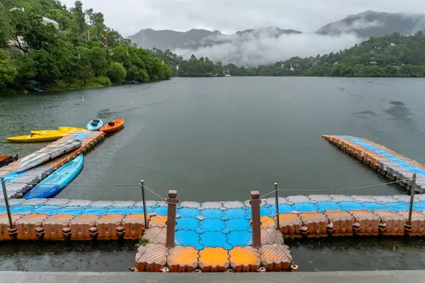 stock image Naukuchiyatal Lake with distant mountain landscapes covered in clouds during the monsoon season, near Almora city, Uttarakhand, India.