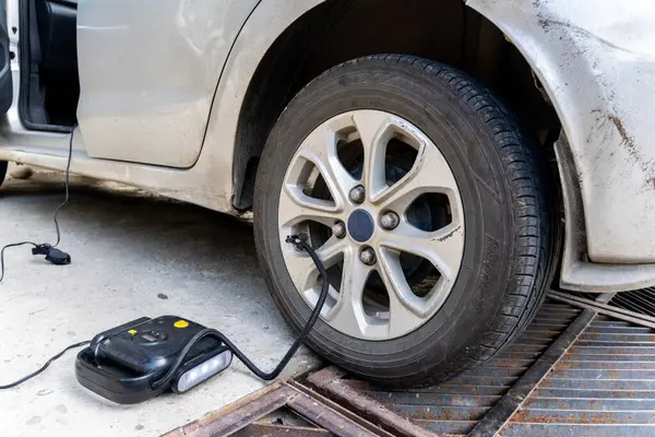 stock image An automated electrical air pressure machine inflating a car tire during an emergency tire pressure situation in Uttarakhand, India.