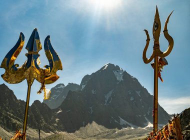 25 Temmuz 2024, Himachal Pradesh, Hindistan. Hindu ve Budist hac yolculuğu sırasında Kailash Parvat 'a karşı Lord Shiva' nın sembolleri olan dini kırmızı kumaşlar (chunri) ve mızraklar (trishul)..