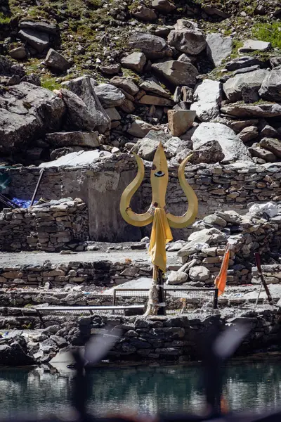 stock image July25th2024, Himachal Pradesh, India. Religious red cloths (chunri) and tridents (trishul), symbols of Lord Shiva, against Kailash Parvat during the Mani Mahesh Kailash Yatra, a Hindu and Buddhist pilgrimage.