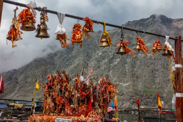 25 Temmuz 2024, Himachal Pradesh, Hindistan. Mani Mahesh Kailash Yatra döneminde, Lord Shiva 'nın sembolleri olan dini kırmızı kumaşlar (chunri) ve mızraklar (trishul), Kailash Parvat' a karşı.,
