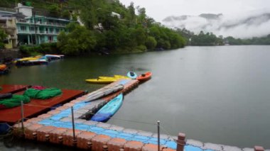 Muson mevsiminde Hindistan 'ın Uttarakhand kenti yakınlarındaki Naukuchiyatal Gölü ve bulutlarla kaplı uzak dağ manzaraları..