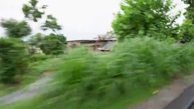 12 Temmuz 2024 Uttarakhand Hindistan. Uttarakhand, Hindistan 'ın dışındaki hızlı bir araçtan küçük evler ve köylerin görüntüsü. Kırsal yolculuğun özünü yol üzerinden yakalar..